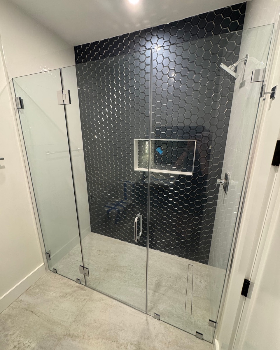 VELA custom frameless glass shower doors against designer black tile in a Maryland bathroom remodel
