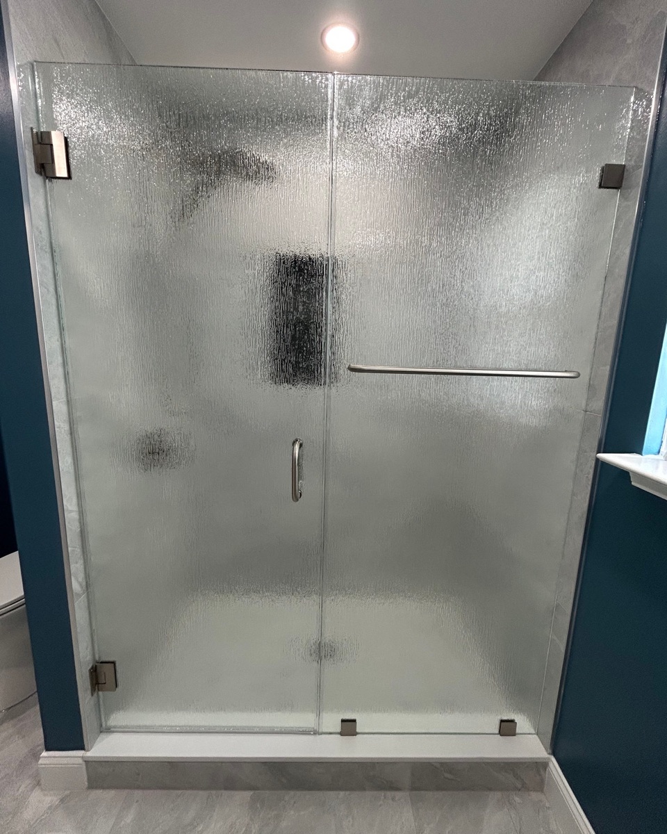 Frameless hinged shower door with rain glass and inline panel, brushed nickel hardware, Maryland