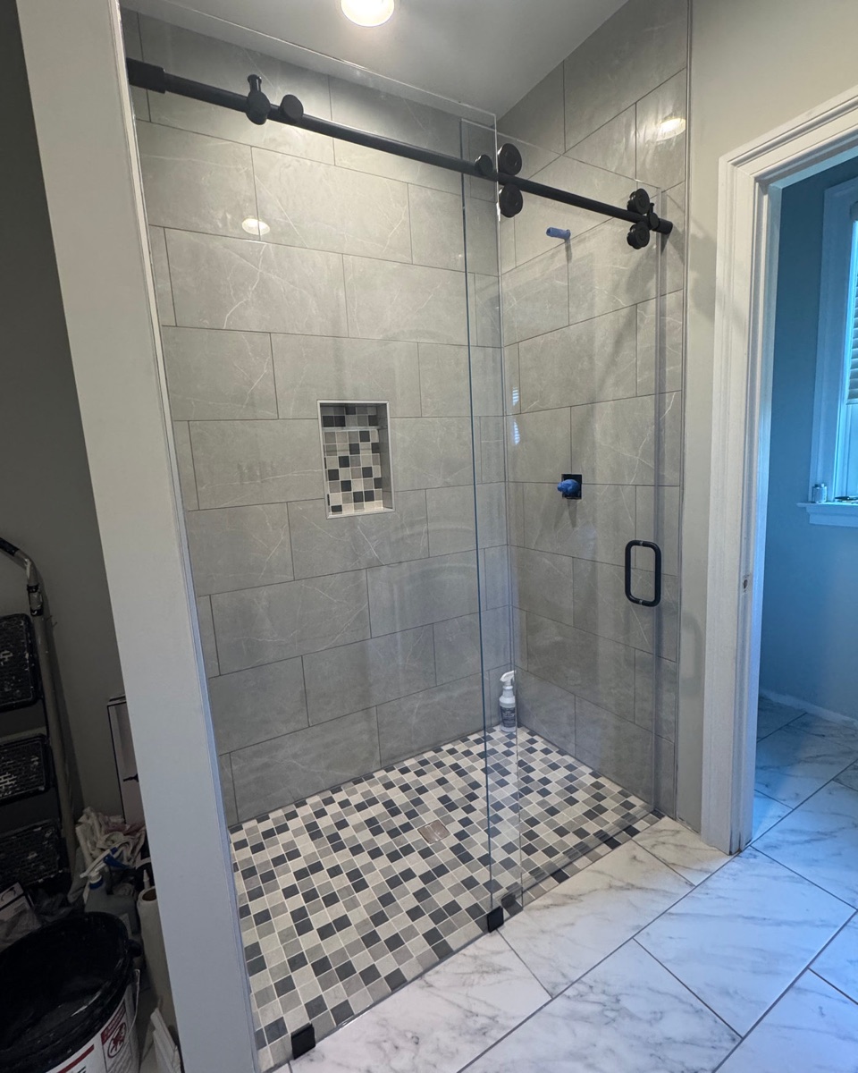 Sliding glass shower doors with matte black hardware in a Maryland home